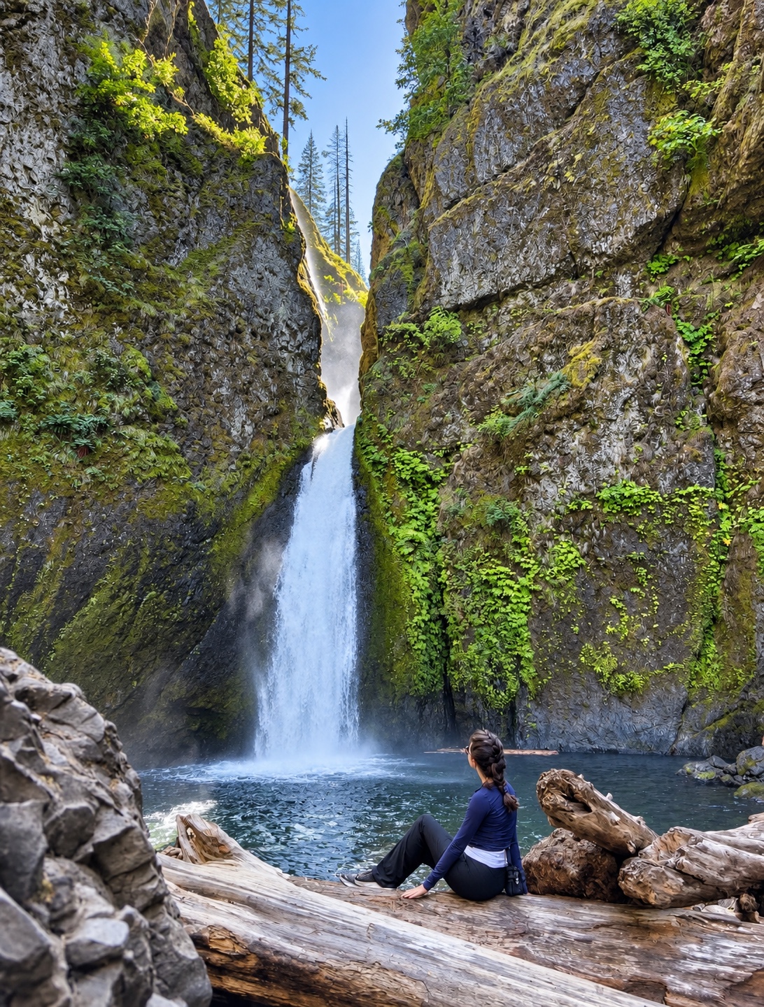 Ranya sitting beside Wahclella Falls in its rocky green canyon