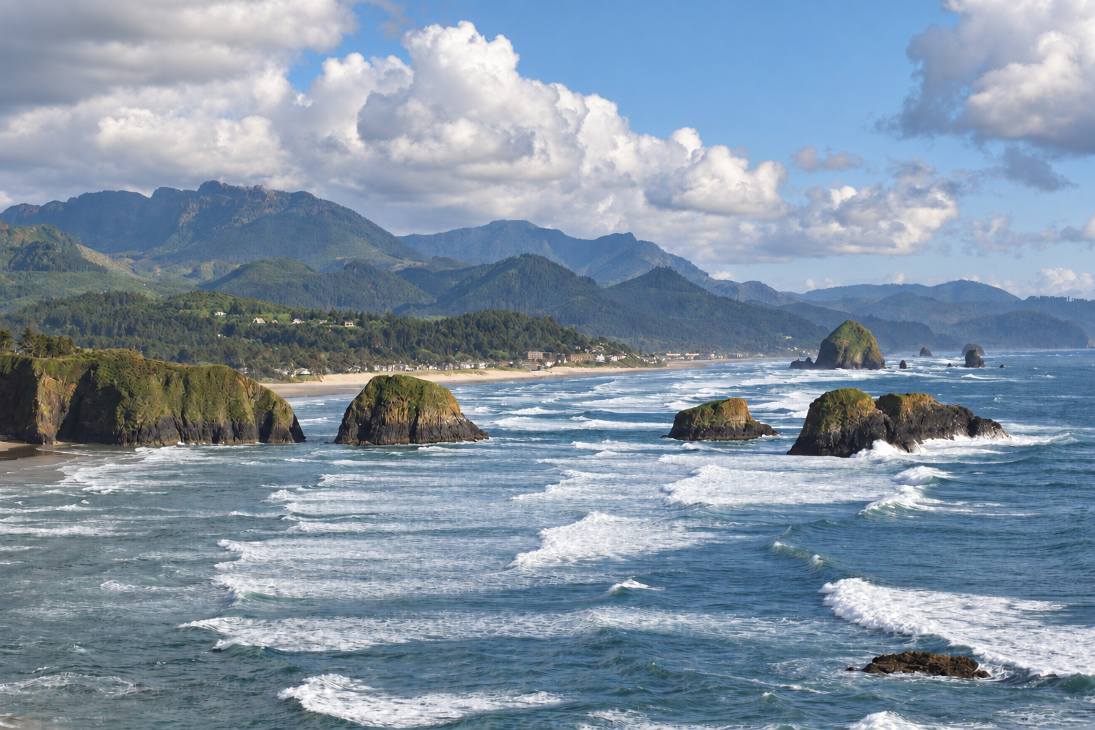 Sunny Oregon coast with blue ocean, sea stacks and green forested mountains