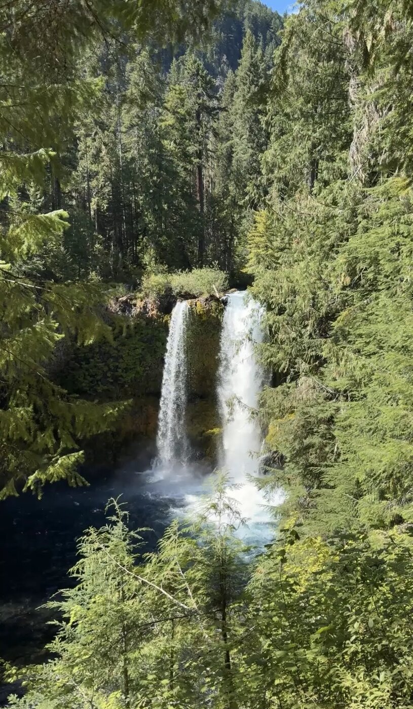 A twin waterfall surrounded by dense green forest