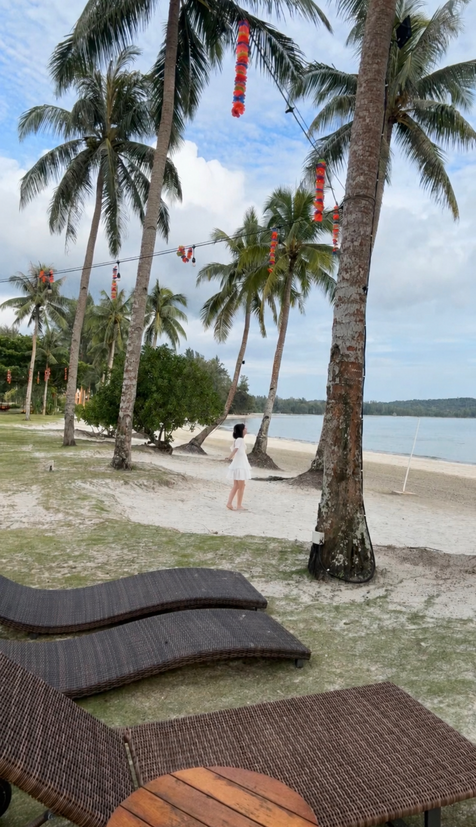 Ranya walking along the palm-lined beach