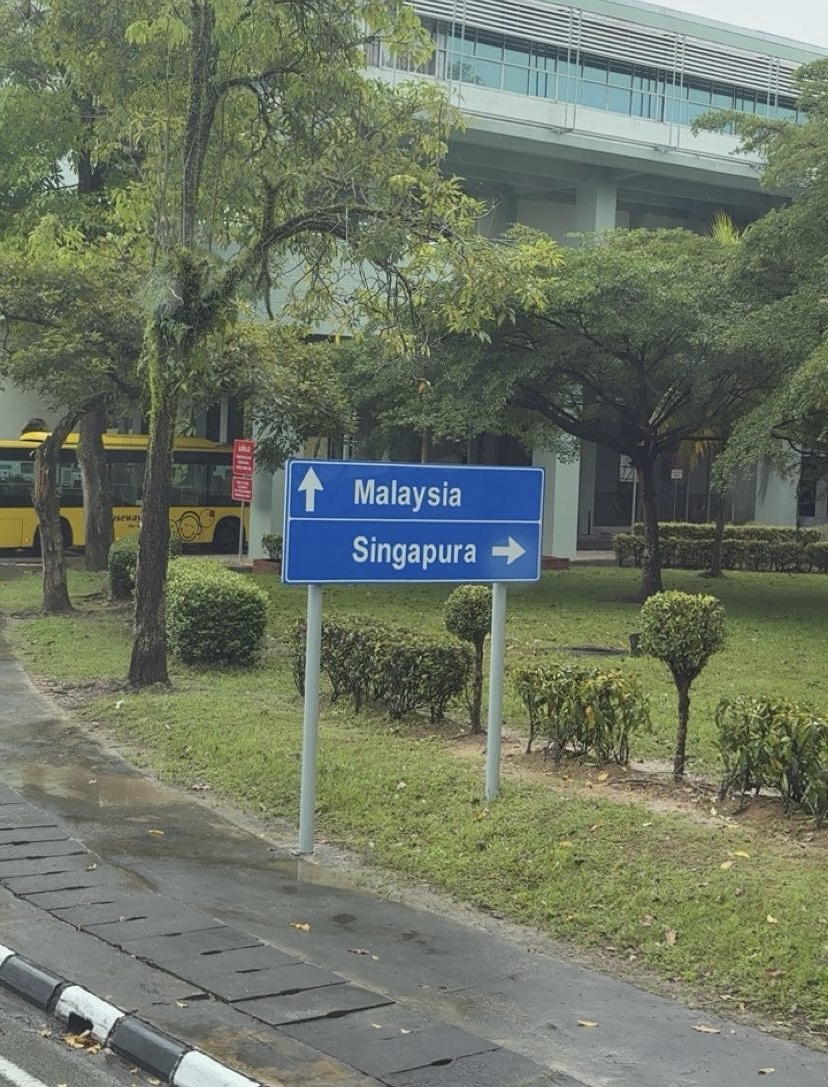Road sign pointing toward Malaysia and Singapore