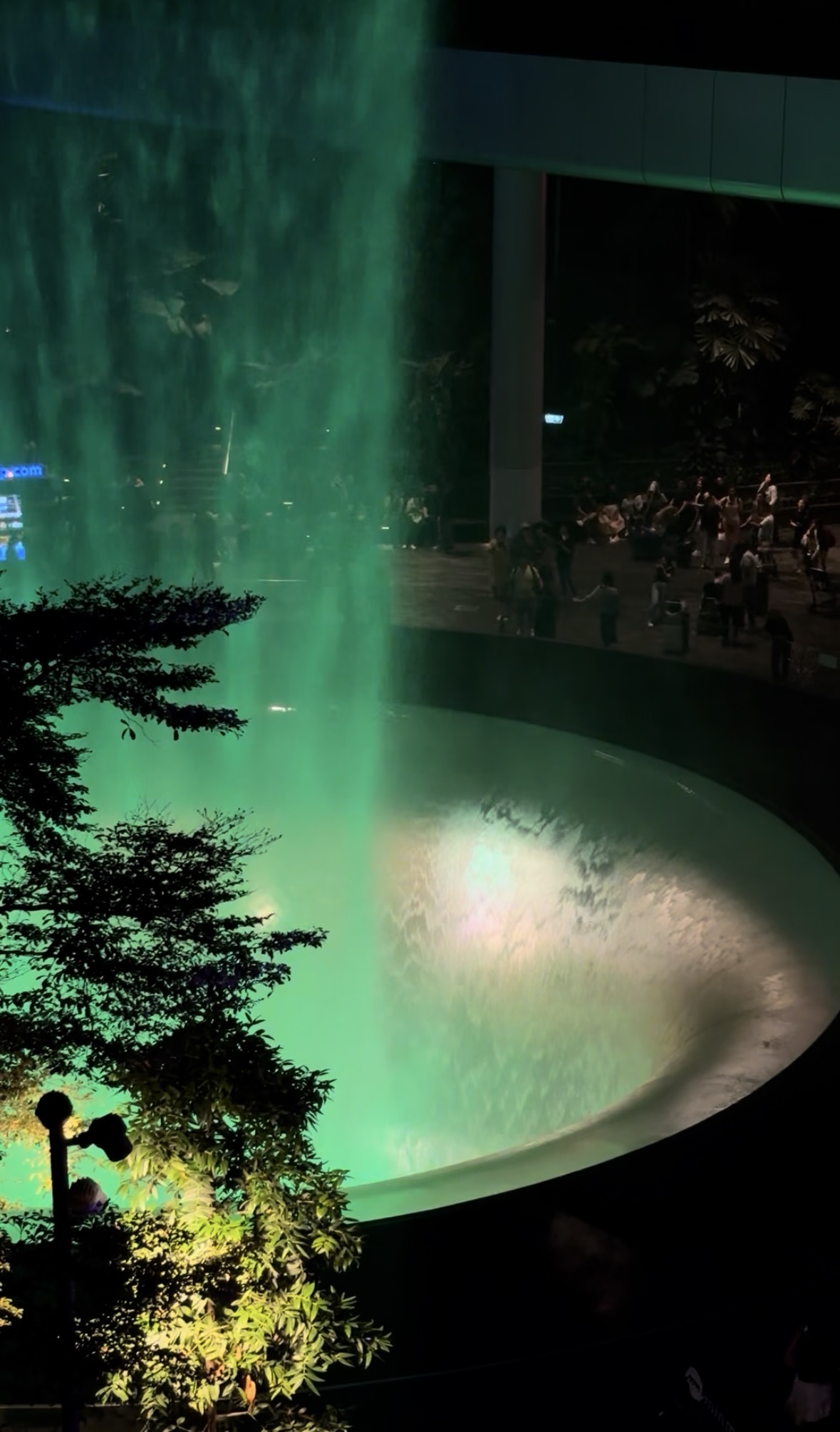 Green light illuminating the waterfall basin at Jewel